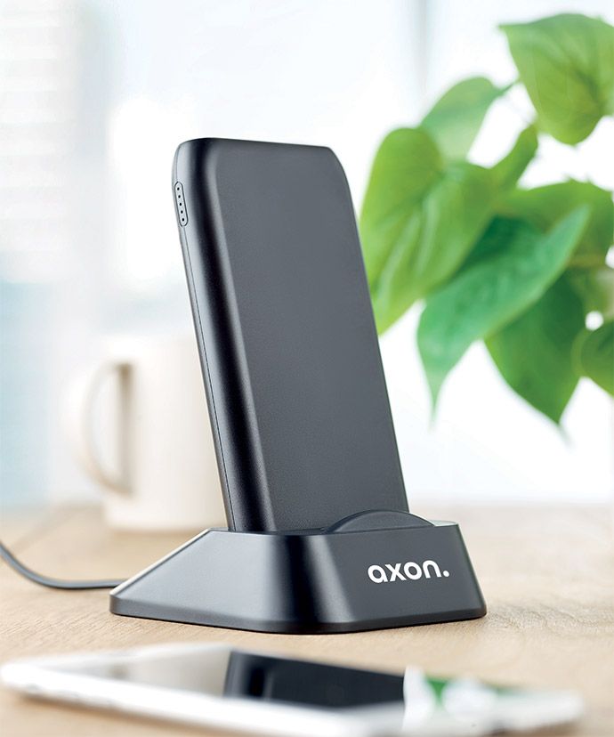 Chargeur sans fil personnalisé noir sur une table. Objets publicitaires pour le bureau.