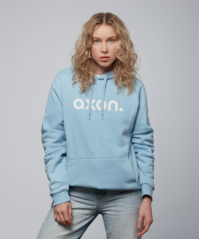 Femme portant un hoodie bleu clair avec un large motif imprimé.